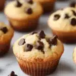 Freshly baked chocolate chip mini muffins on a cooling rack.