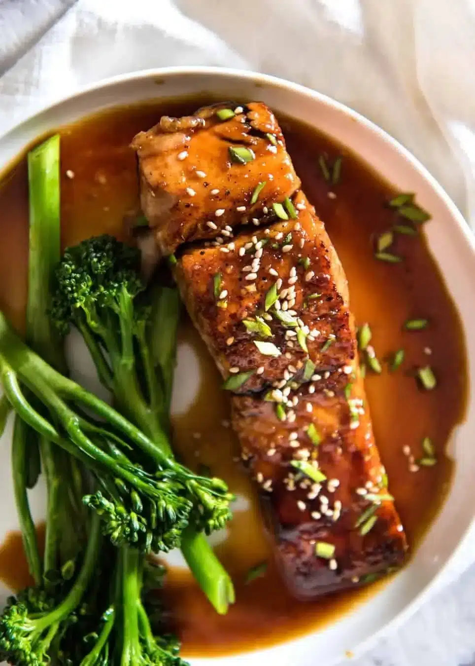 Plate of Honey Garlic Salmon garnished with herbs and served with vegetables.