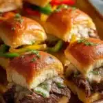Philly Cheesesteak Sliders topped with melted cheese on a platter