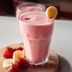 Delicious strawberry banana smoothie in a glass with fresh fruit