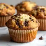 Cream cheese-filled banana chocolate chip muffins on a wooden table