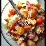 Fresh garden summer panzanella salad with colorful vegetables and bread