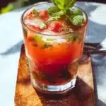 A refreshing Minty Strawberry Mojito cocktail garnished with mint and strawberries.