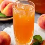 Glass of sweet tea with fresh Southern peaches on a sunny day.