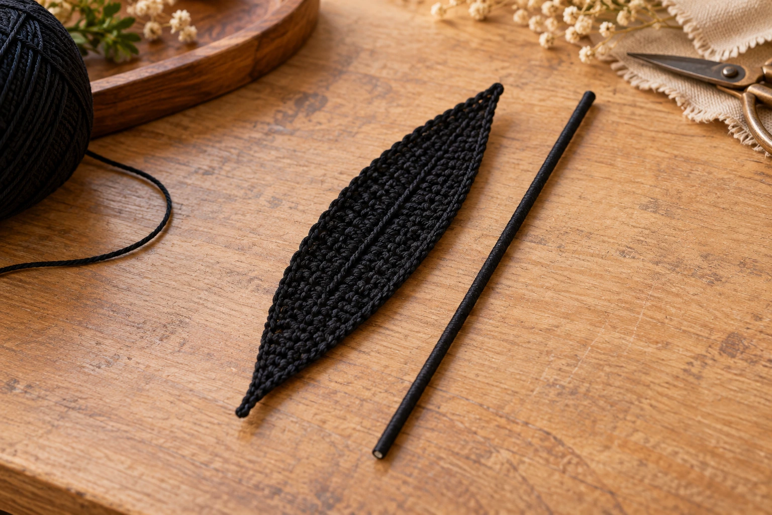Black crocheted leaf with wire along its center and a small picot edge
