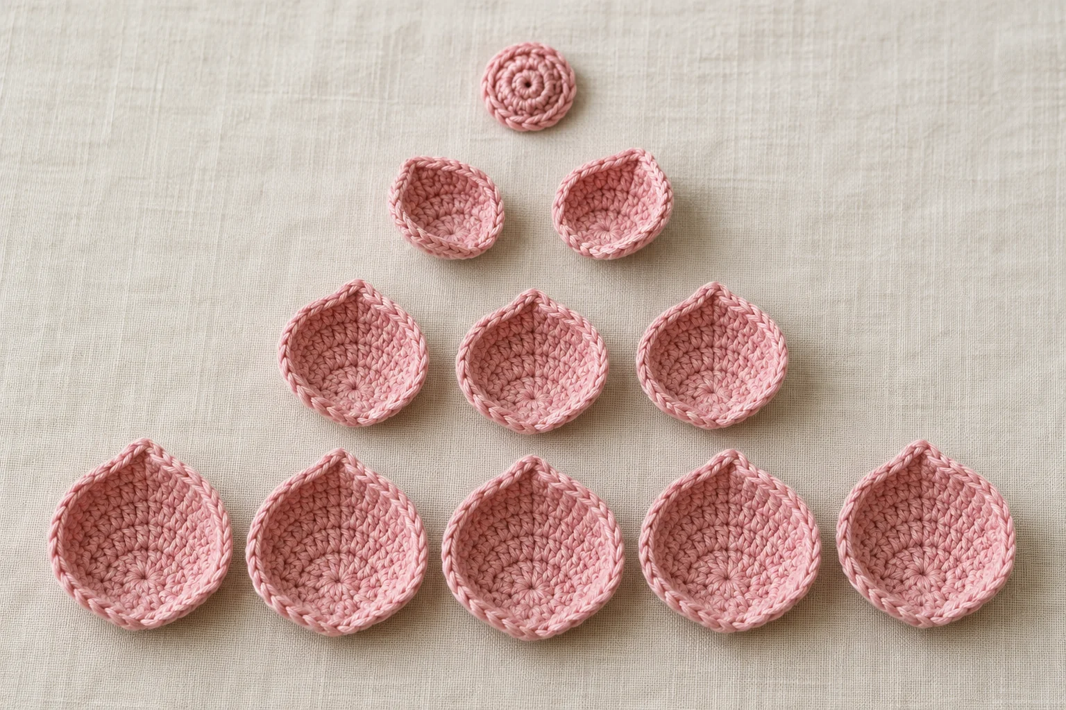 Pink crochet rose center with exactly two small, three medium, and five large petals arranged in separate rows